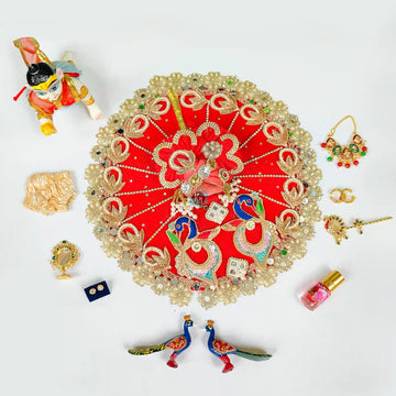Red more patch dress, 1 nappy, ittar, mirror, mala, kangan, bansuri, earrings and peacock pair