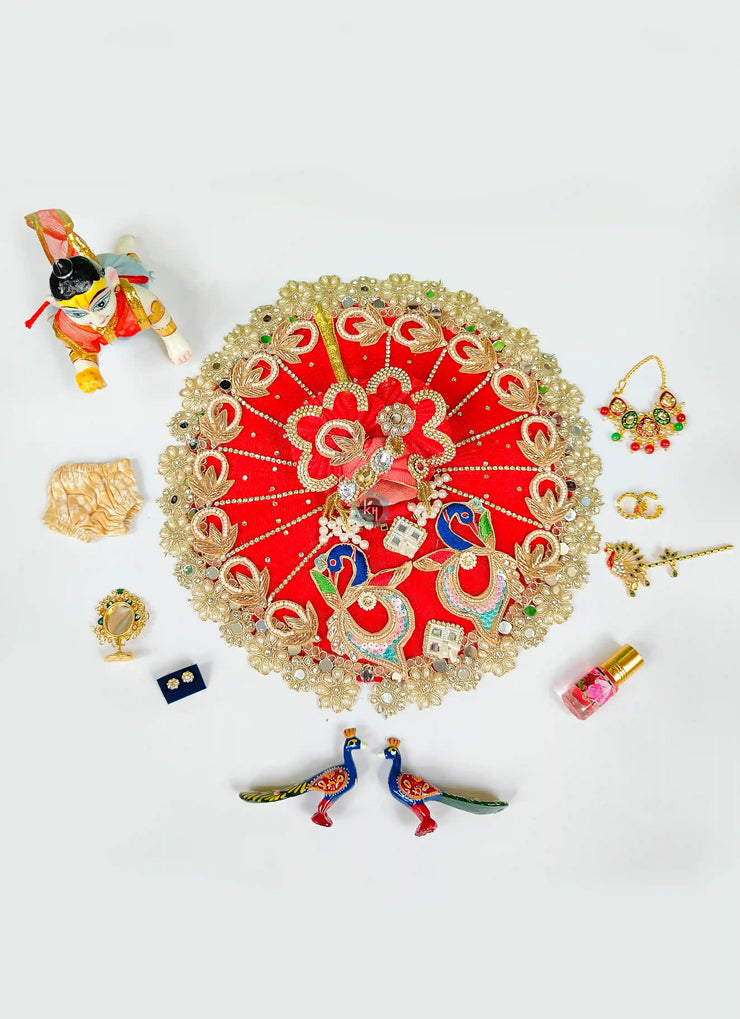 Red more patch dress, 1 nappy, ittar, mirror, mala, kangan, bansuri, earrings and peacock pair